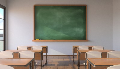 classroom with a green board and tables in front of it