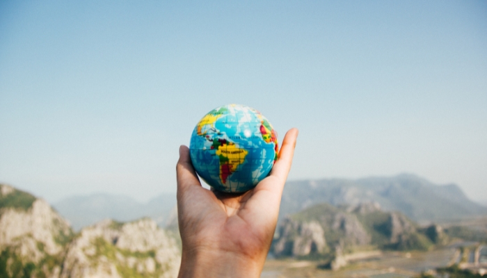 person holding a small globe in their hand representing global citizenship