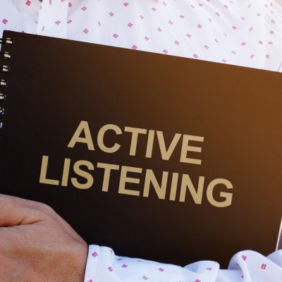 person holding a folder that says active listening on it